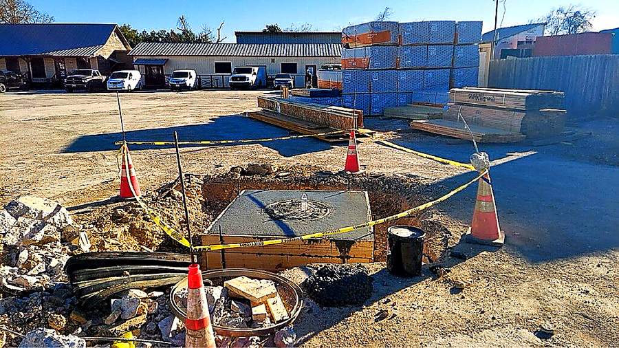Finished concrete manhole pad after underground utility work in San Antonio